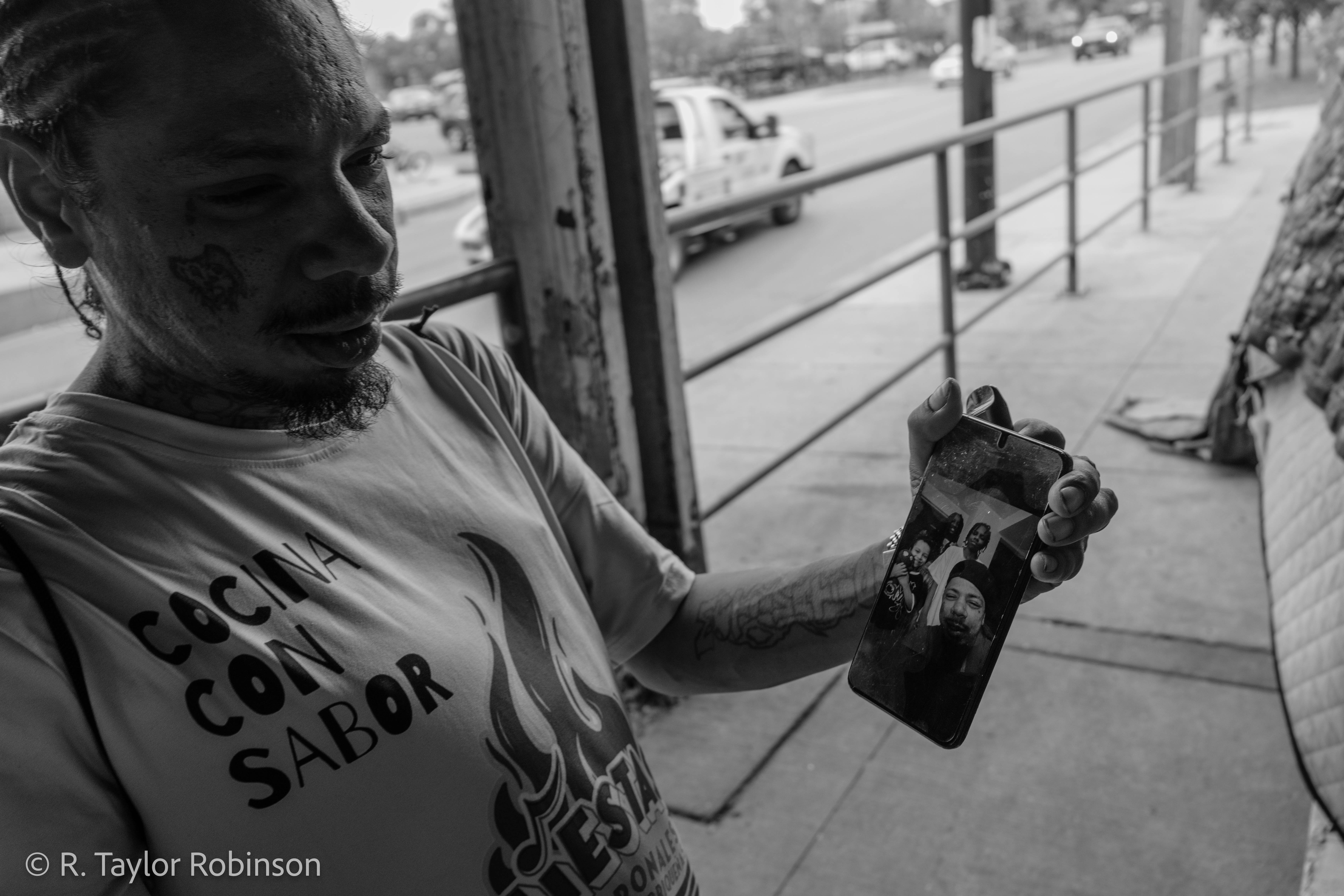 Gonzalez shows a photo of his son, daughter and stepson on his phone.