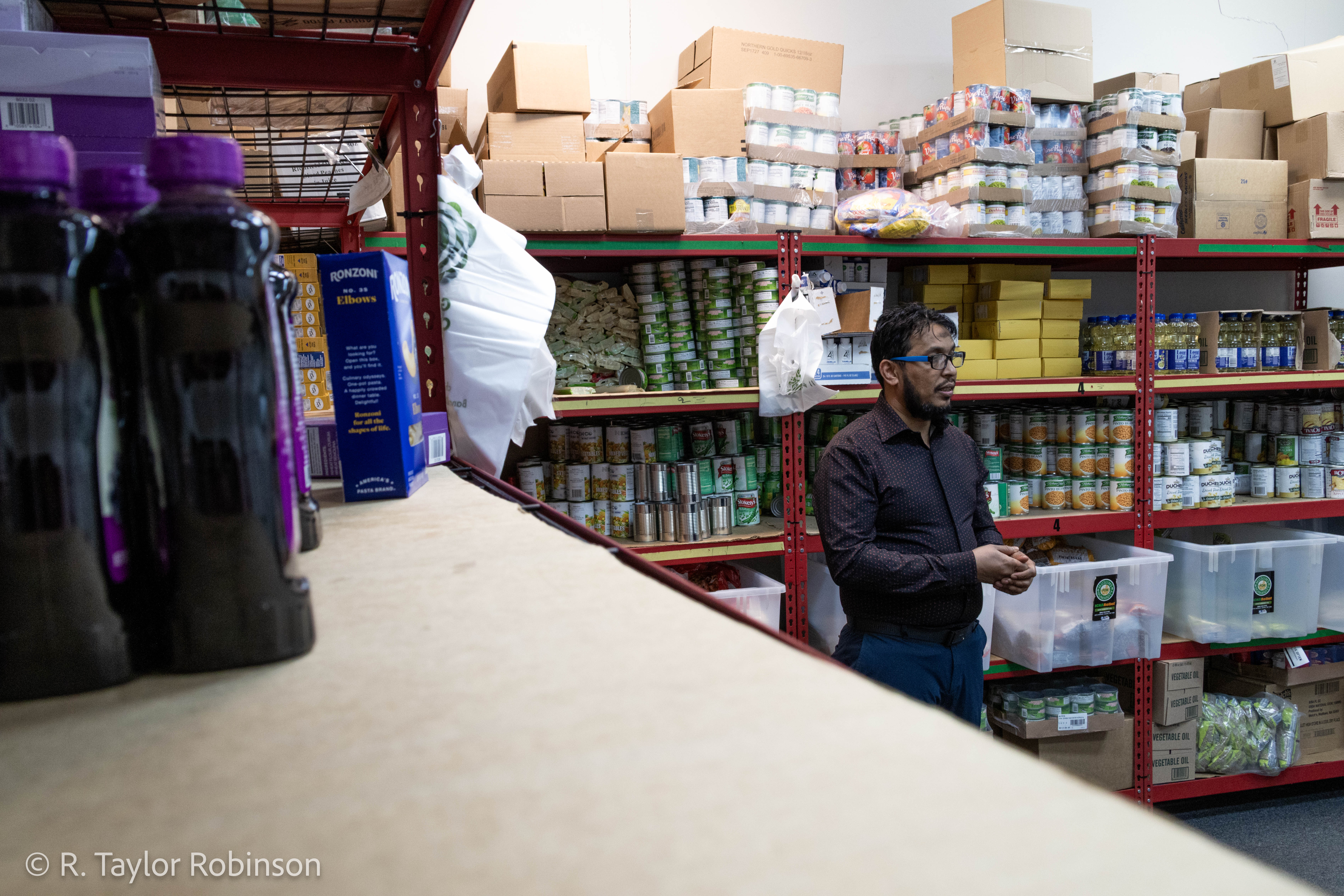 Kamal stands in the food pantry, where he initially started working when he first joined ICNA. Kamal originally comes from Myanmar and is Rohingya, a persecuted minority ethnic group in the country, when he was 17 he saw his family killed and siblings burned alive along with 4,000 houses in his neighborhood. "I was studying (by) myself. I'm reading the book in the dining room, and my dad was screaming," Kamal said. "I went in there, by the time I go there my dad got shot … My mom is screaming, 'go away, go away, go away.’ My mom doesn't let me go inside, and then when I escape, my mom also got shot."