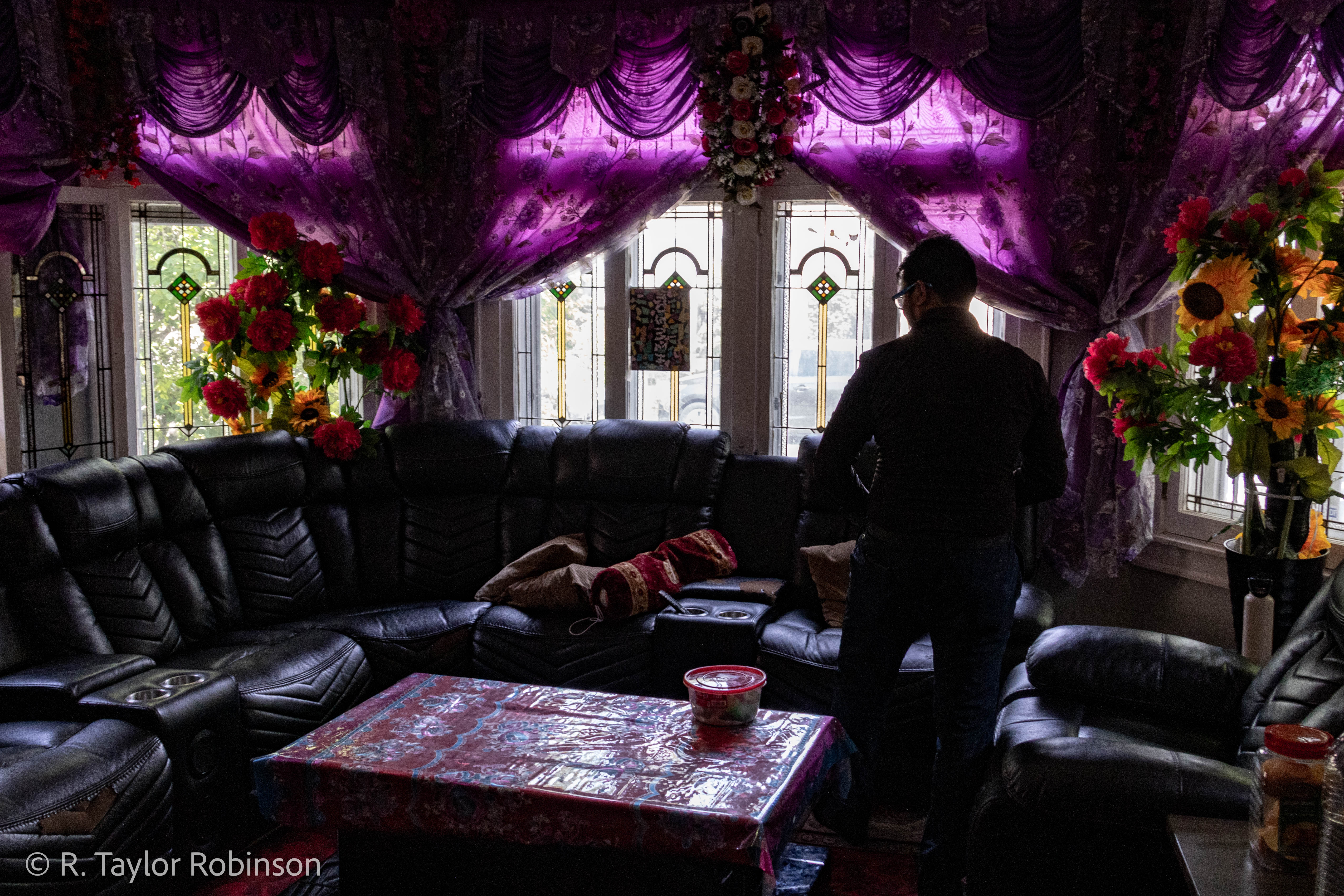 Kamal prepares to take a seat in the living room of the house he owns. He bought it during COVID at an incredibly low interest rate, a fact he is very proud of. After escaping from his pursuers into the jungle and hiding in a bush he was discovered a day and a half later by his uncle. "When he found me, he decided to say, ‘you know what, let's cross to Bangladesh, there's no way to return home,’" Kamal said. "And I went with my uncle, crossed to Bangladesh."