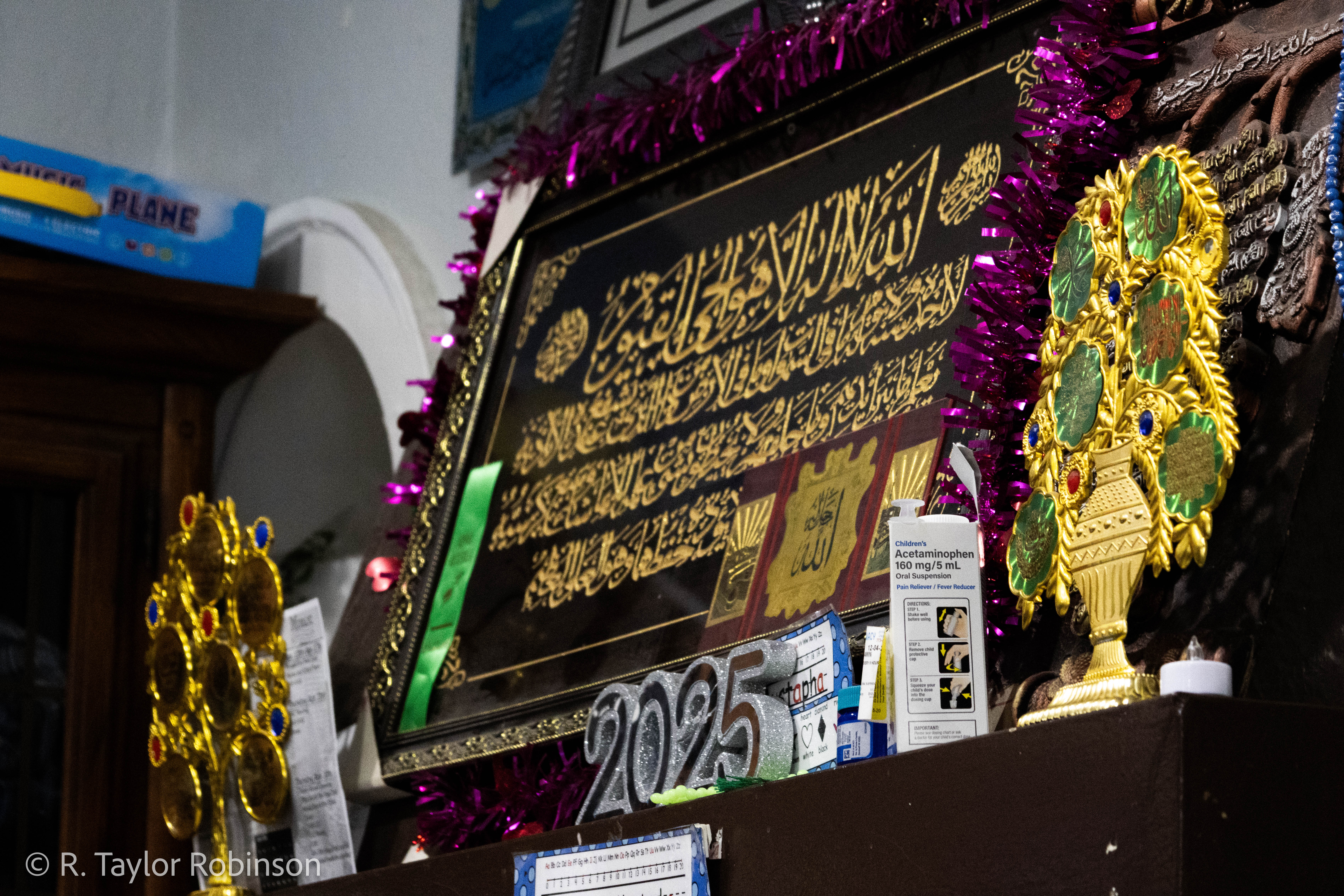 Islamic calligraphy, the box for a bottle of acetaminophen, tinsel, artificial candles and a plastic ‘2025’ adorn the mantle. During his stay in the deportation center, he decided to learn Sri Lankan by asking the officer the meanings of words using English as a shared language. "Every night I have to memorize at least 20 words," he said. "That's the only job I have. I have nothing to do there, you know. And I took notes–two months later I speak very fluent their language." He laughs.