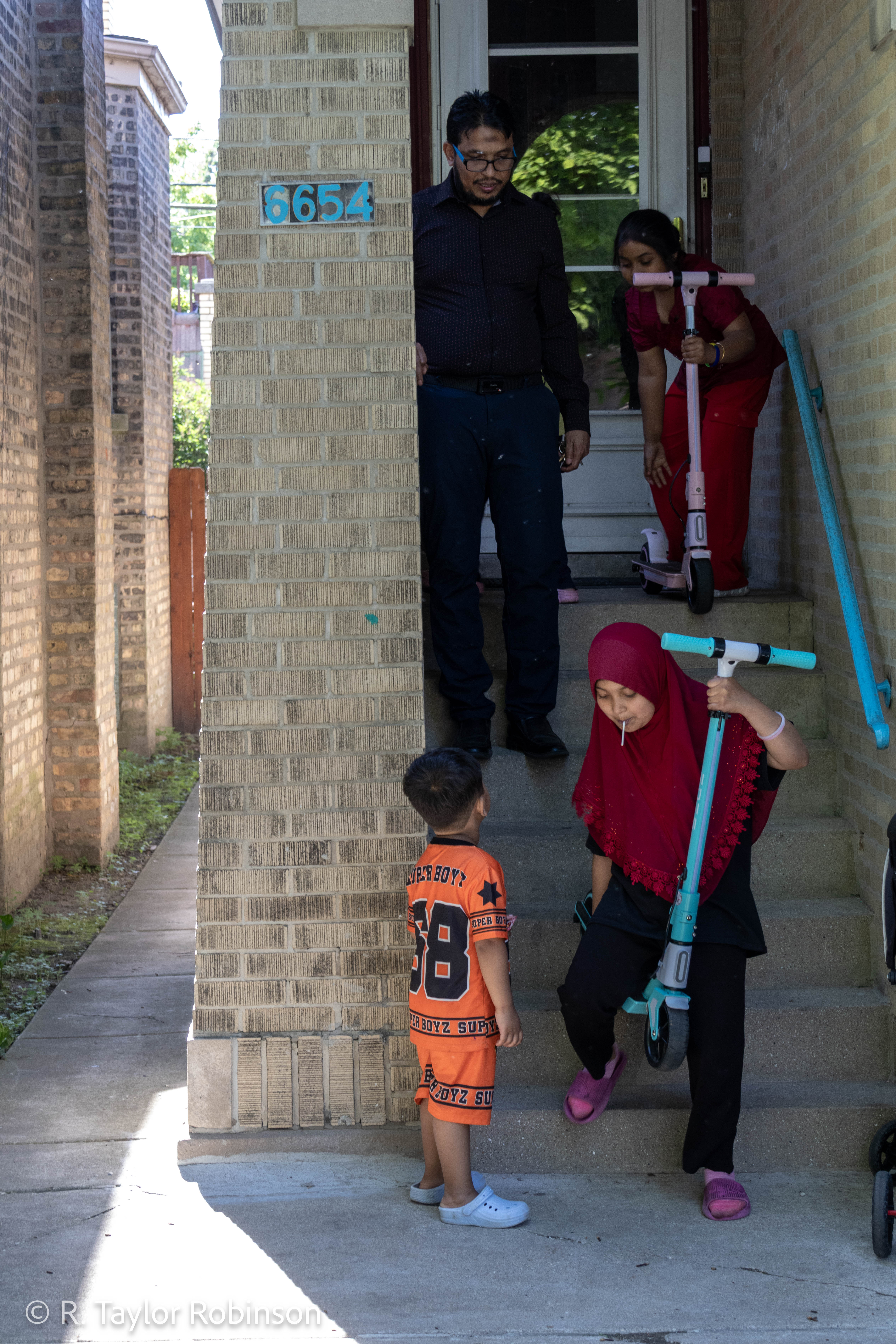 Kamal’s older two daughters, Tosmin, 8, and Yasmin, 9, grab their scooters from inside for an afternoon ride as Aziz looks up at his father. Kamal speaks nine languages now: Rohingya, Burmese, English, Bengali, Hindi, Urdu, Spanish, Tamil and Singhalis (from Sri Lanka). He said his experience as a refugee inspired him to help others the same way he was helped by a case worker when he arrived in New Hampshire in 2012.