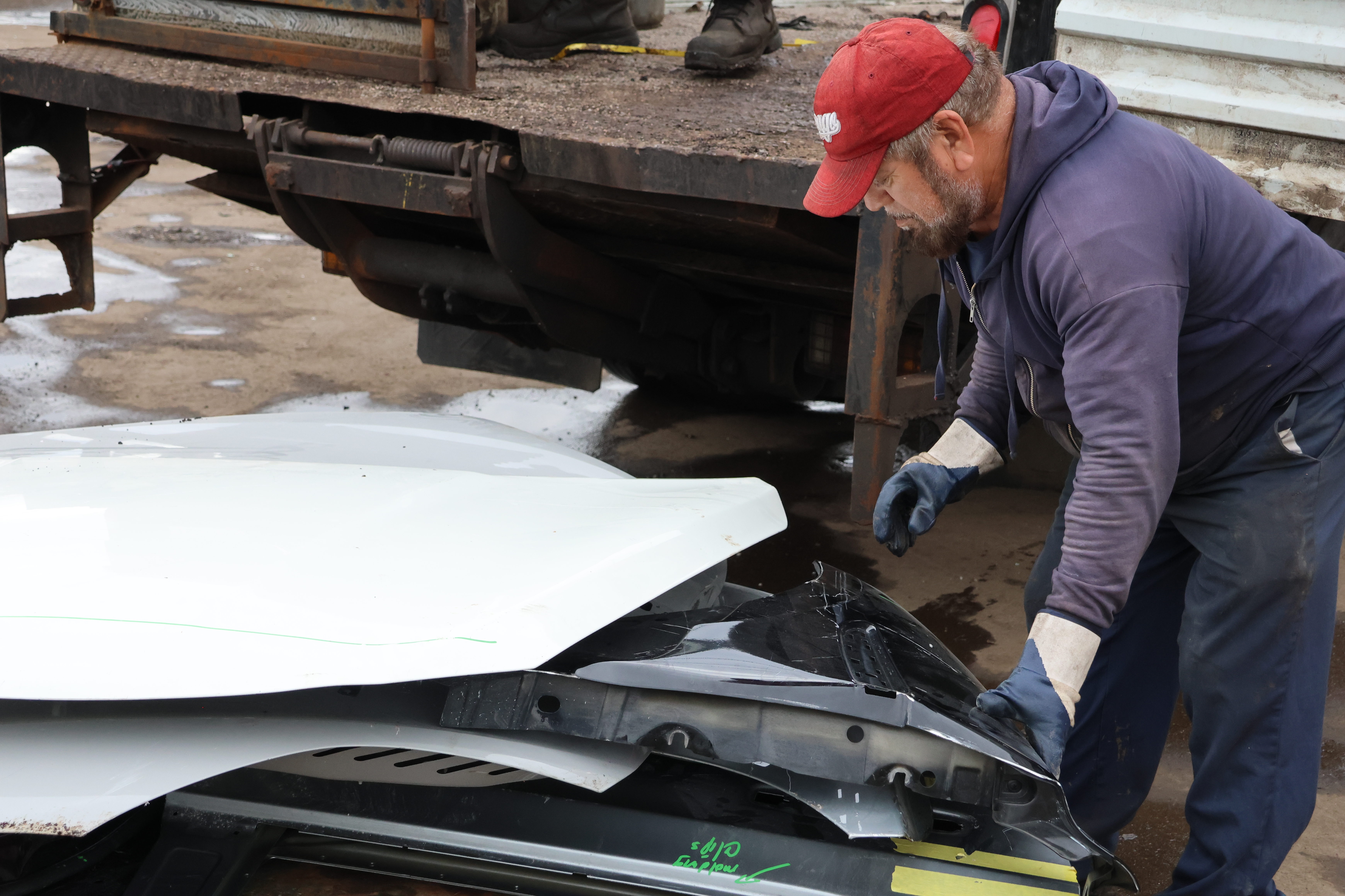 Fernando Florian, 70, a customer at the scrap yard, loads a cart with scrap metal such as car doors and engine hoods. His birthday is next month.