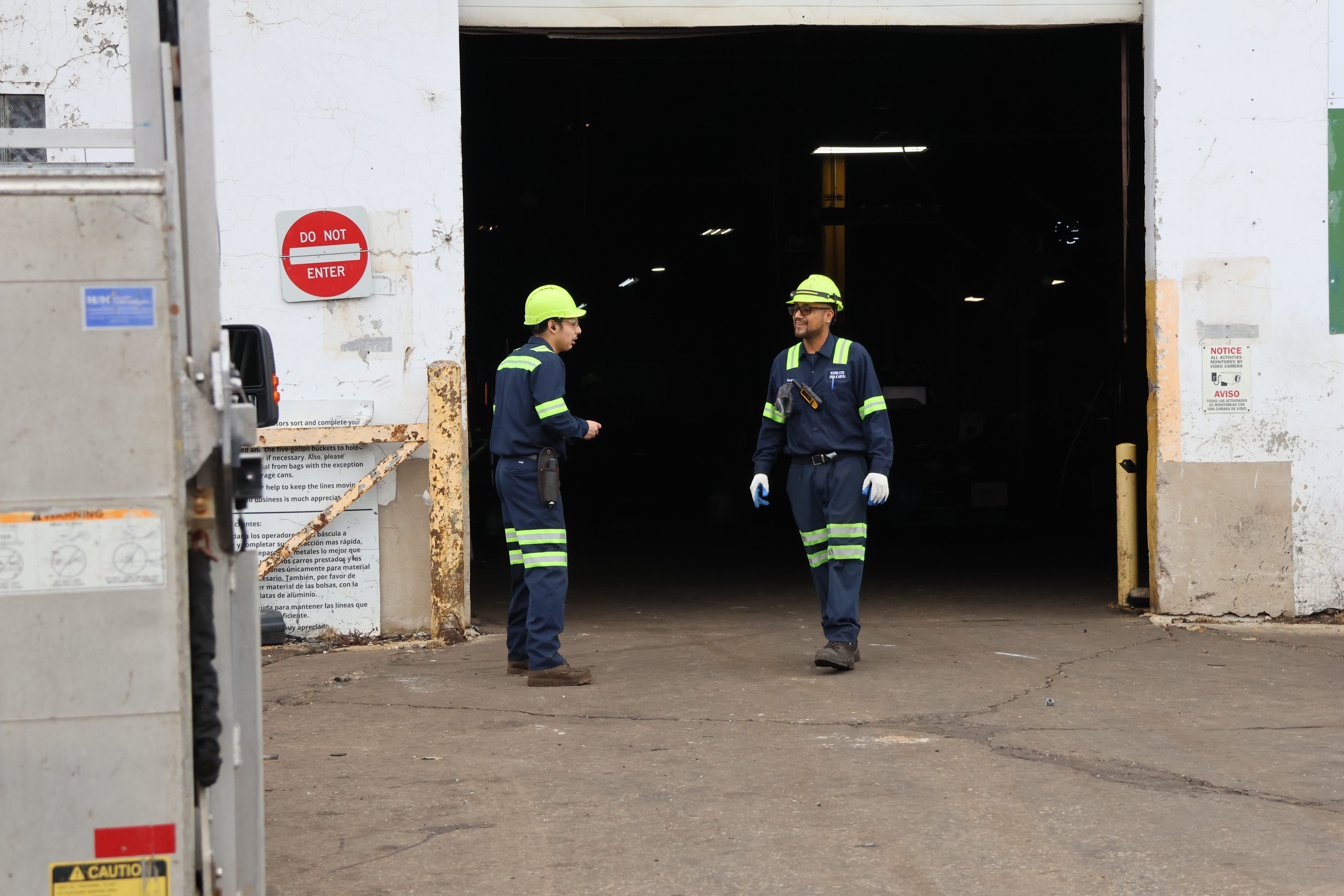 Francisco Pineda, another worker at Windy City Iron & Metal speaks with his coworker Angel Estrada, 19. Pineda likes to go by Pancho.